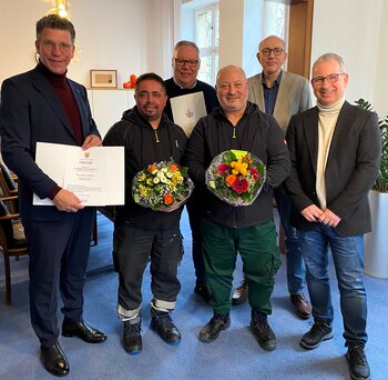 Bajram Rexhepi (2.v.l.) und Kemal Selimi (4.v.l.) feiern ihr 25-jähriges Dienstjubiläum. Bürgermeister Volker Klüter (l.), Bauhofleiter Bernd Uerpmann (M.), Personalchef Frank Staffel (r.) und Bauamtsleiter Marcus Henninger (2.v.r.) gratulieren.